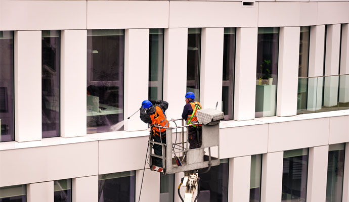 Workers are washing windows with a big lift.