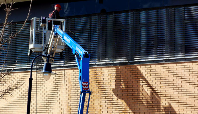 worker pressure washing hotel window