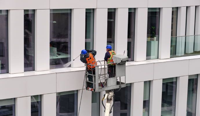 A couple of professionals pressure washing a commercial property