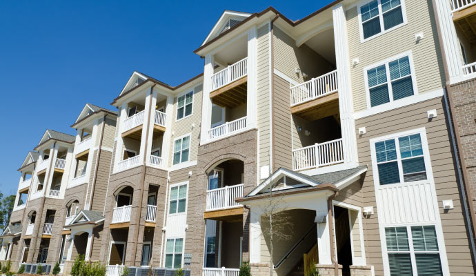 multi-story apartment building with balconies and large windows