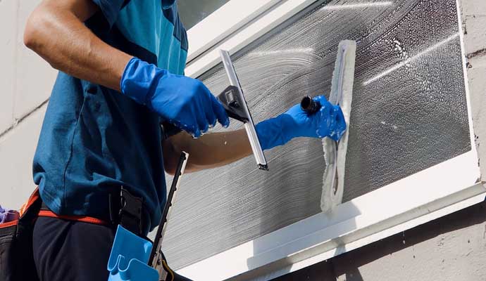 a person washing window using squeegee