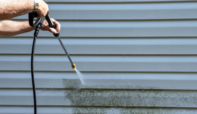 cleaning house siding with pressure washer