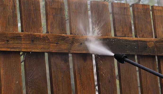 high-pressure washer cleaning wooden fence