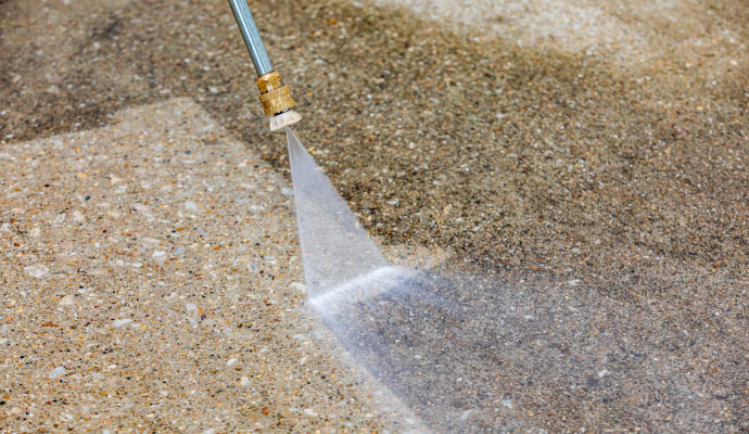 A pressure washer cleaning a concrete surface