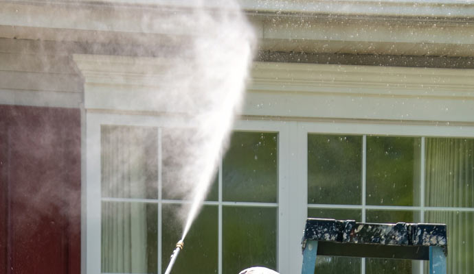 a stream of water being sprayed onto a residential window for cleaning purpose