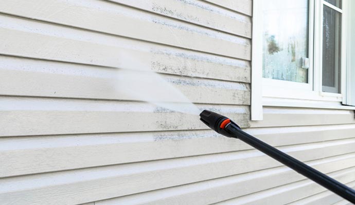  a house with siding undergoing soft washing