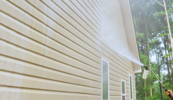 Cleaning the exterior of a house using soft wash.