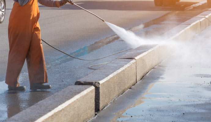 Person cleaning street with equipment